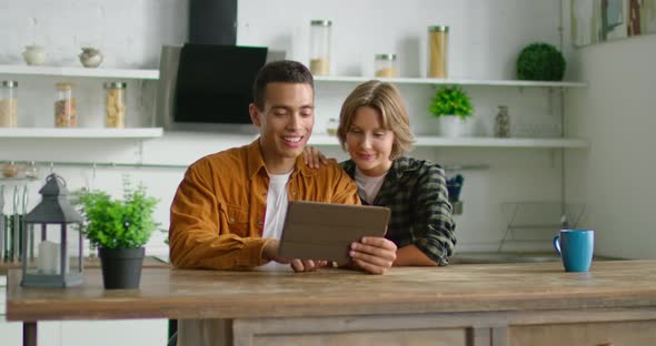 Latin Man and White Woman Talking Via Video Application on Tablet Computer