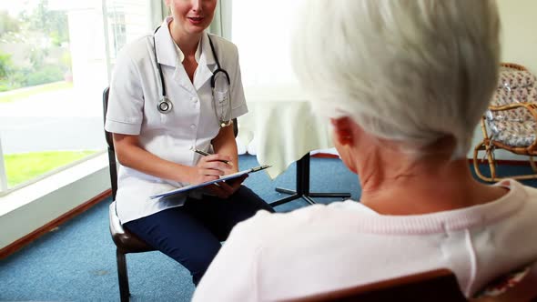 Nurse talking with a patient senior woman