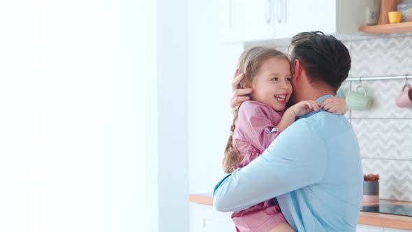 Hugging young father and little daughter in home interior