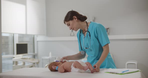 Doctor Measuring Temperature of Little Baby with Noncontact Thermometer in Clinic