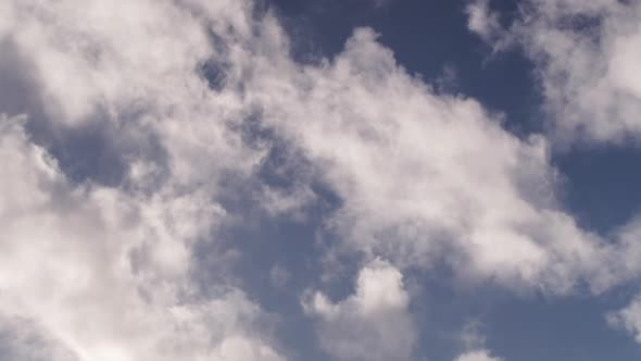 Clouds float by on a sunny day.