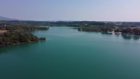 Aerial view over a beautiful landscape with a magnificent natural lake, and its turquoise waters sur