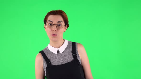 Portrait of Funny Girl in Round Glasses with Surprised Wow Face Expression. Green Screen