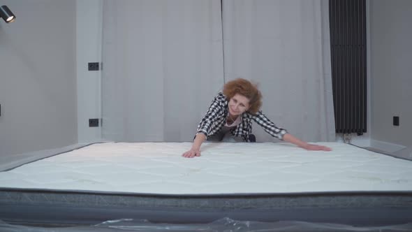 Senior Woman Feeling Happy About Her New Comfortable Mattress at Home