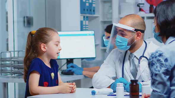 Doctor Talking with Child Wearing Protection Mask