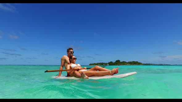 Young couple in love on relaxing coast beach voyage by turquoise ocean with white sandy background o