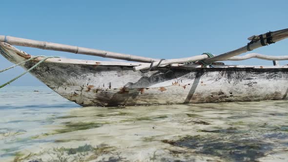 African Traditional Wooden Boat Stranded in Sand on Beach at Low Tide Zanzibar