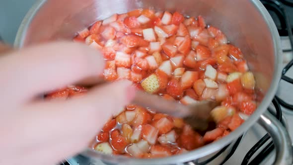 Preparing strawberry jam, stirring boiling pot, slow motion