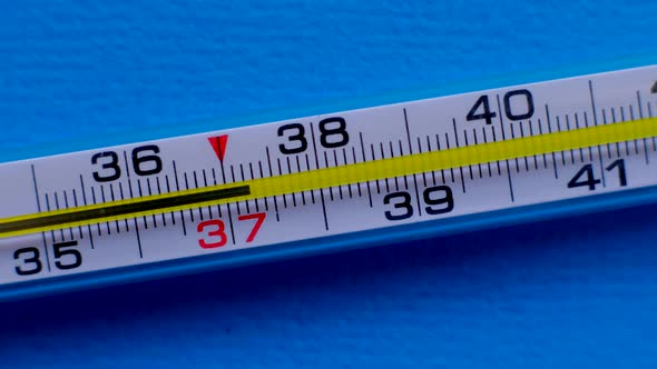 Temperature Rising Shown on a Thermometer on a Blue Background Closeup