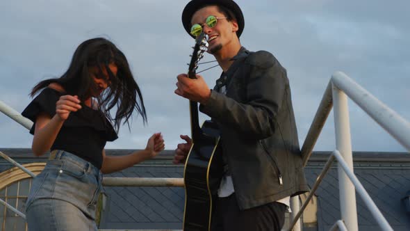 Two people playing guitar and dancing