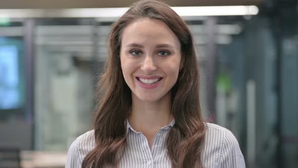 Portrait of Attractive Young Woman Smiling at Camera  in Cafe