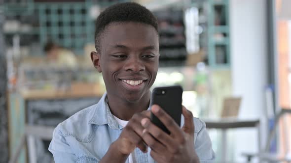 Cheerful African Man using Smartphone