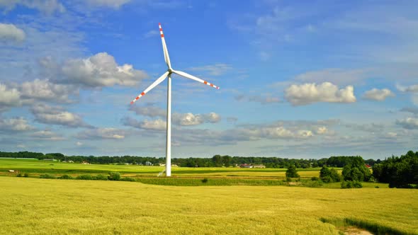 White wind turbine on field, aerial view in summer