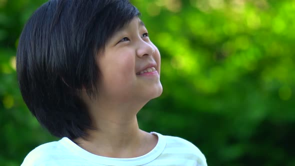 Close Up Of Happy Asian Child Looking Up With Nature Background