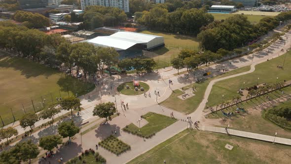 Aerial orbiting view of a roundabout in Vicente Lopez coastal walk and a sport club behind