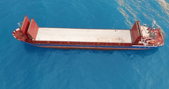 Aerial View. Red Deck Cargo Ship Sailing on Open Sea.