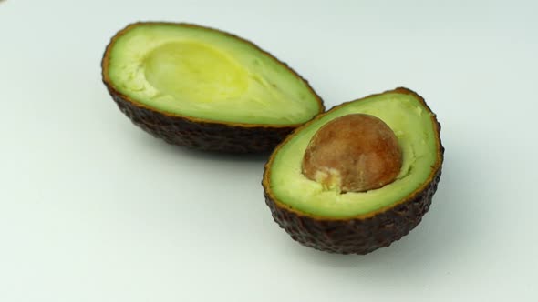 Avocado rotates on a green grass background. 4K video close-up of wholesome and healthy food.