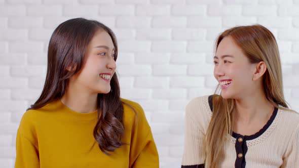 LGBTQ Asian lesbian young couple smiling holding pride flag happiness with love together