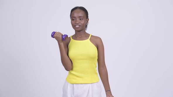 Young African Woman Exercising with Dumbbells