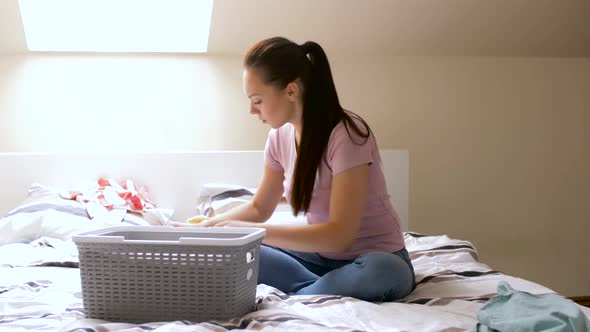 Woman or Housewife Sorting Laundry at Home 