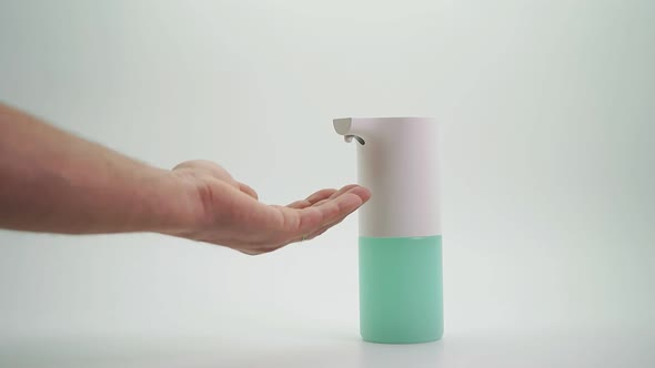 Close-up of Hands Disinfected with a Foam Automatic Dispenser, Isolated Background. Protection From