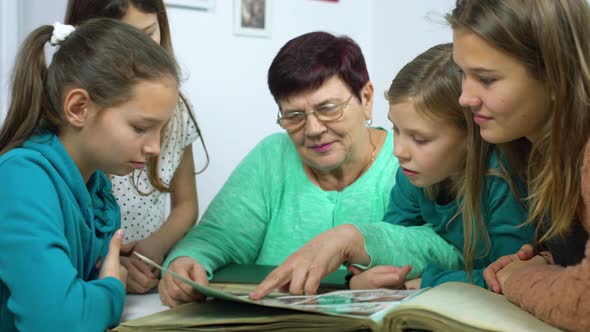 Grandmother Showing Old Photo Album to Her Granddaughters