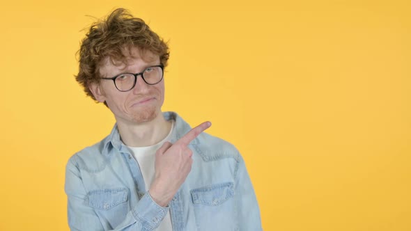 Copy Space Redhead Young Man Pointing with Finger Yellow Background