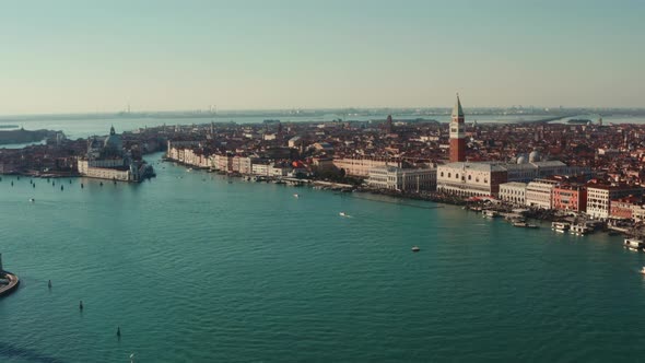 Low circling drone shot over Venice Lagoon of St Marco Square and Basilica di Santa Maria