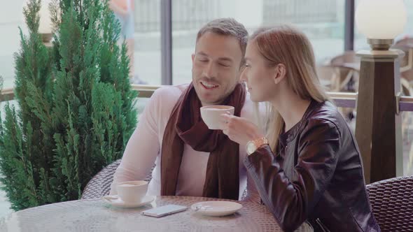 Couple Drinking Coffee On Date At Cafe Outdoors