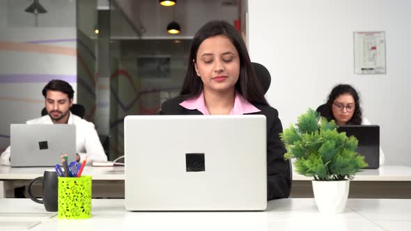 Indian businesswomen working on a laptop in an office environment