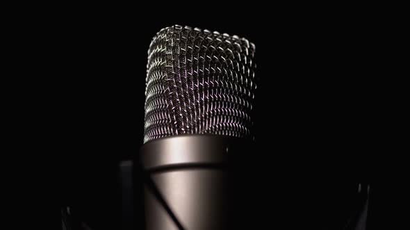 Studio Condenser Microphone Rotates on Black Background