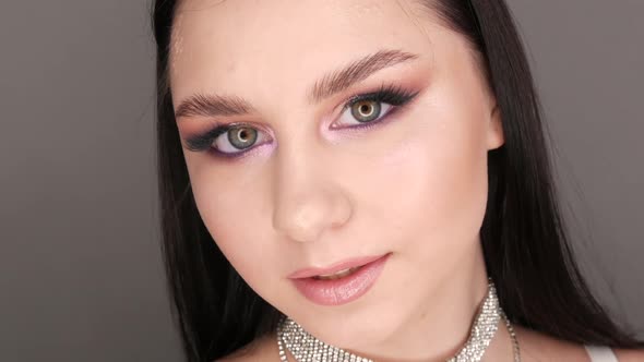 Portrait of a Beautiful Young Girl Model in Stylish Evening Make Up Smoky Eyes Looks at the Camera