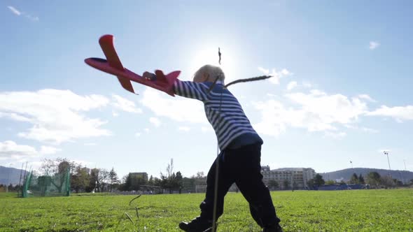 Boy Playing Outside with Toy Airplane