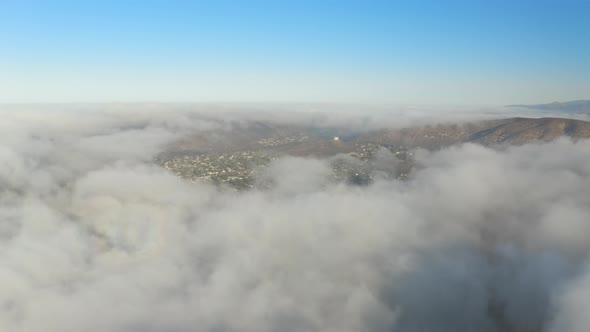 Aerial view of low fog over mountains in San Diego during sunrise