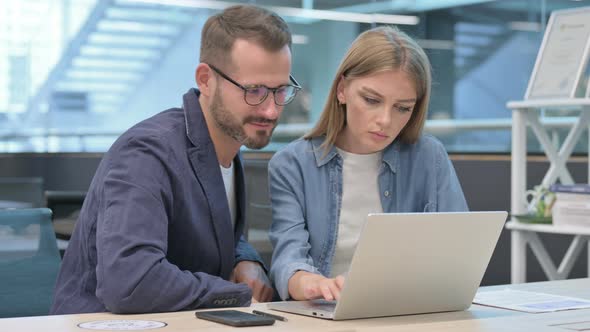 Male Colleague Harassing Female Colleague While Working on Laptop in Office