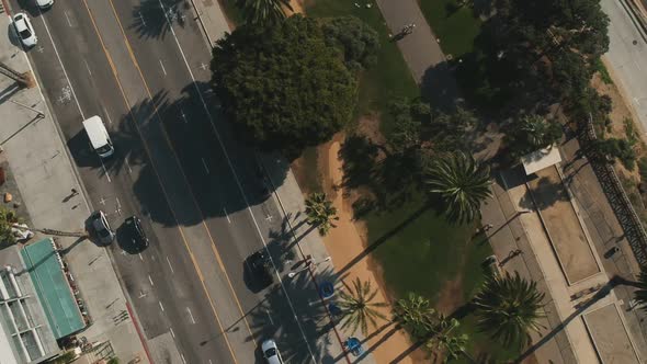 Afternoon drone view from Ocean Ave public road and moving across a pedestrian park near Santa Monic
