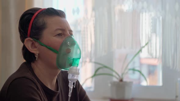 A European Woman at Home Carries Out Inhalation Inhalation of Oil Vapors Oxygen Through a Mask