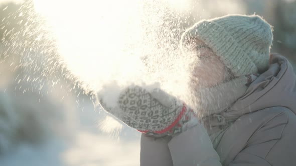 SLOW MOTION Young Woman Blowing Snow