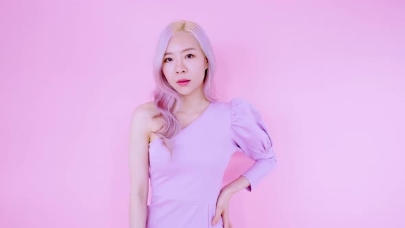 Asian young woman standing and posing with pink background