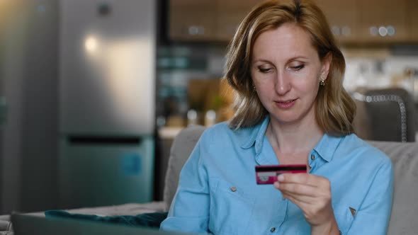 Middle Age Caucasian Woman Entering Credit Card Banking Data on Laptop Rbbro