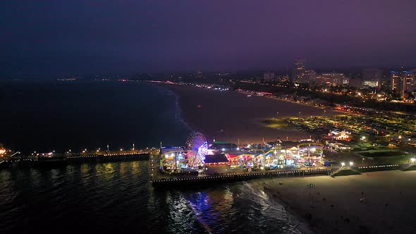 Great aerial drone shot of the Ferris wheel and roller coaster at the Santa Monica Pier in southern