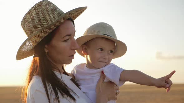 Happy Family Mom and Little Son at Sunset Silhouette