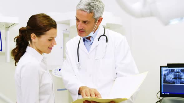 Dentist discussing report with female patient