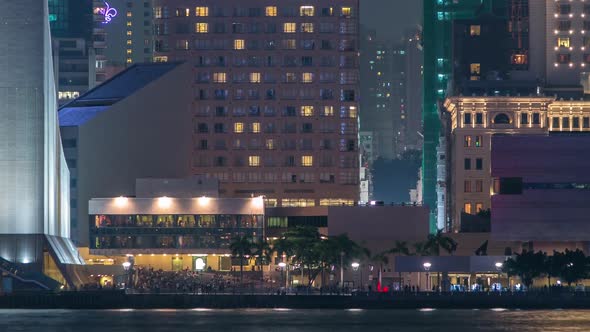 People Sitting on the Stairs Near Hong Kong Cultural Centre with Palms and Towers on Background