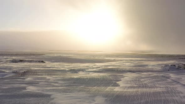 Bright Sun Obscure With Cloud Shining Over Snowy Field And Road At Winter. - aerial pullback