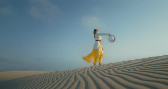 Woman in Stylish Clothes Is on Rippled Texture Sand Desert Surface with Blue Sky