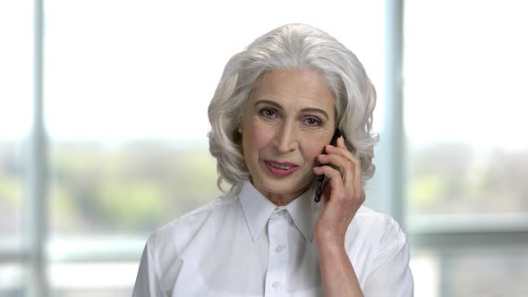 Portrait of Old Cheerful Lady Talking on Phone