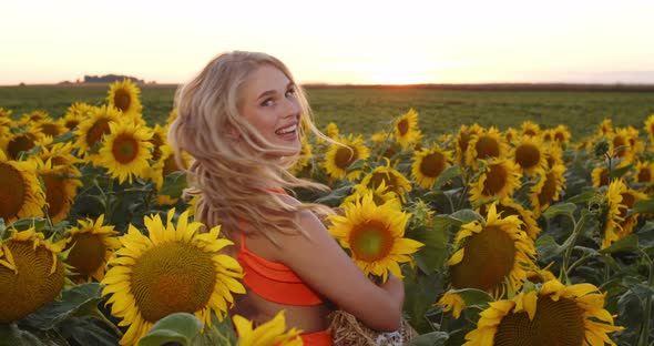 Beautiful Young Joyful Girl in a Sunflower Field