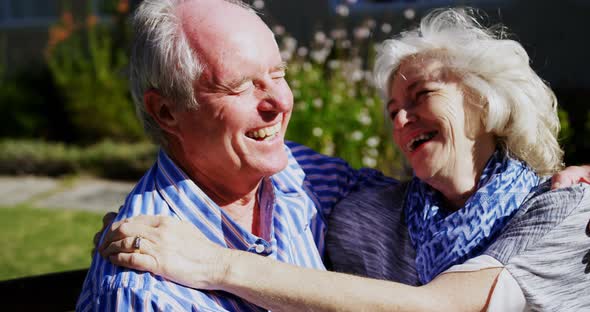 Front view of active Caucasian senior couple embracing each other in the garden of nursing home 4k