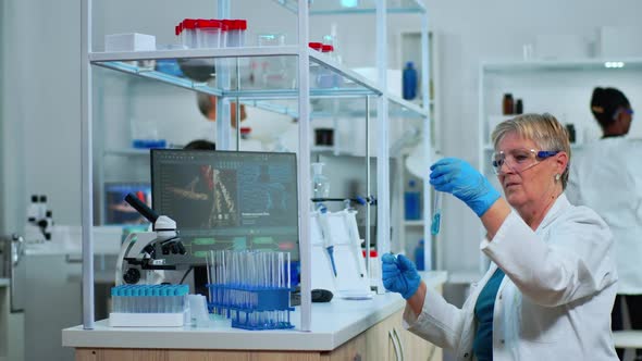 Microchemist Doing Research Checking Liquid in Test Tube at Laboratory